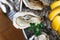 Close up Top view of Fine de Claire Oyster and Many kinds of Fresh Oysters served in round tray with slice lemon and spicy sauce