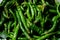 Close up top view of freshly harvested green chillies  displayed in market for sale.