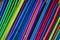 Close up top view of a group of new colored plastic straws.