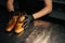 Close-up top view of hands of shoemaker shoemaker in black gloves holding old worn light brown leather shoes