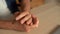 Close-up top view hands of unrecognizable nervous young man snapping fingers sitting at desk in home office.