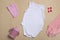 Close-up top view. Mockup blank pink bodysuit, pink pants, hat and cup for newborns on a beige background, with copy space -