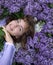 Close-up, top view portrait of young beautiful woman 17-18 years old among flowers of lilac color of very peri