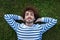 Close up top view of serene, relaxed young man lying down on grass with eyes closed.