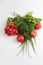 Close up top view shot of a vegetable composition consisting of a bunch of radish, dill, parsley, green onions and ripe red