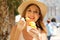 Close up of tourist girl eating gelato traditional italian ice cream in Sirmione town, Italy. Young woman with hat holding ice