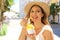 Close up of tourist girl visiting Sirmione town in Italy holding traditional gelato italian ice cream looking to the side