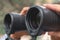 close up tourist holding binocular and searching the way, macro lens view