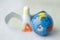 Close up of toy bird next to earth globe against white b