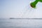 Close Up of a toy watering can pouring a shower of water on the beach. Fun with children on the beach