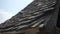 Close-up tracking shot of wooden old roof in sunlight in warm sunny day on northern France. Detail cropped shot of old