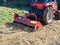 Close-up of a tractor with a chain mower chopping dry grass. Maintenance of the territory, mulching of grass, agricultural