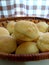 Close-up of traditional Brazilian cheese bread (pÃ£o de queijo) in a basket. Delicious snack.