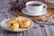 Close-up of traditional British scones and a cookie on a plate with a teacup and flower blurred background. Space for text
