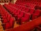 Close-up of traditional, classic empty chairs upholstered in red velvet, the interior of the theater