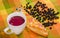 Close up of traditional Ecuadorian dish, colada morada and guaguas de pan with some mortinos, over a colorful fabric