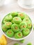 Close up of a traditional Eid cookies known as Onde-onde pandan flavour topped with crunchy caramelised coconut shreds.