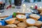 Close up traditional english festive pastry mince pies on wooden tray with blue napkin with blurred mulled wine drinks and lights