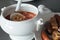 Close up of a traditional fabada home made. A ladling serving fabada from a bowl and side dish with the traditional compango, with