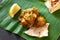 Close up traditional Indian butter chicken curry and lemon served with chapati bread on banana leaf