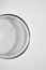 Close-up transparent shower gel in glass petri dish on white background. Cosmetic texture