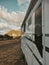 Close up of Travel vehicle concept with modern camper van motor home parked free in tha nature with mountains and sunset in