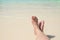 Close up traveler cross barefoot leg laying on beach at sea shore,Relaxing in summer vacation time