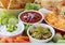 Close up of a tray of various popular appetizer dips ready for sharing.