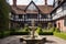close-up of the tudor house exterior with a view of the gardens and fountains