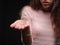 Close-up tuft of hair on a hand. Sad woman holding tangled, problematic hair on the black background. Hair loss concept.