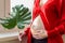 Close up tummy of pregnant woman with exotic green leaf