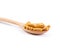 close up the Turmeric capsule in wooden spoon on white