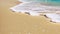 Close-up of turquoise sea wave coming to sand of a tropical beach