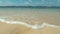 CLOSE UP: Turquoise waves roll in on the peaceful shore on tropical island.