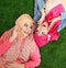 Close up two beautiful happy muslim woman lying on grass