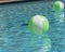 Close-up two bright green beach ball in swimming pool sunny day