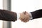 Close up two businessmen in suits handshaking after successful negotiation