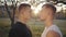 Close-up of two Caucasian sportsmen looking at each other in sunlight. Serious adult boys standing outdoors.