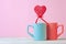 Close up of Two cups and heartshaped lolipop or hard candy on table. pink background. Place for text. copyspace. St. Valentine`s