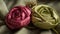 a close up of two fabric flowers on a bed sheet with a pine cone on the side of the flower and a pine cone on the other side of