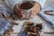 Close-up of two female human hands  holding a dark chocolate cup, creamy and thick. Wooden table as background and scarf