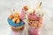 Close up of two freak shakes topping with blue and pink donuts,