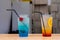 Close up of two fruity cocktails in transparent disposable glasses with straws for sale at the street food festival