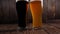 Close-up of two glasses of beer on a wooden background, dark beer and light beer