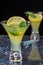 Close-up of two glasses of mojito, with selective focus, with lime and mint slices on blue marble and vertical