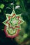 Close-up of two hand made mandalas of woolen threads hanging on tree branches in the autumn forest, selective focus