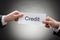 Close-up of two hand\'s holding credit paper