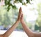 A close-up of two hands on a blurred park background. A female hand giving five a male hand. Relationship and friendship