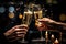 Close-up of two hands clinking glasses of champagne with bokeh background, Hands of couple with flutes of champagne and their