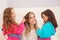 Close up of two litle girls playing with the hair of their mom, while curly girls is wearing a pink bathrope and